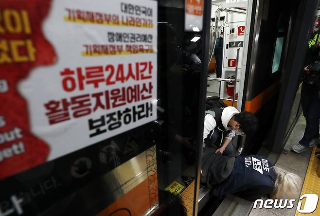 박경석 전국장애인차별철폐연대(전장연) 상임공동대표가 21일 오전 서울 경복궁역 3호선 열차에서 장애인권리예산 확보 및 장애인 이동권 보장 촉구 시위를 펼치고 있다.  2022.4.21/뉴스1 © News1 구윤성 기자