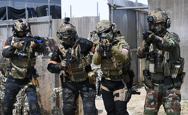 게임 시작에 앞서 각종 안전장비를 착용하고 전투복을 입은 동호인들이 에어소프트 건을 들고 포즈를 취하고 있다.