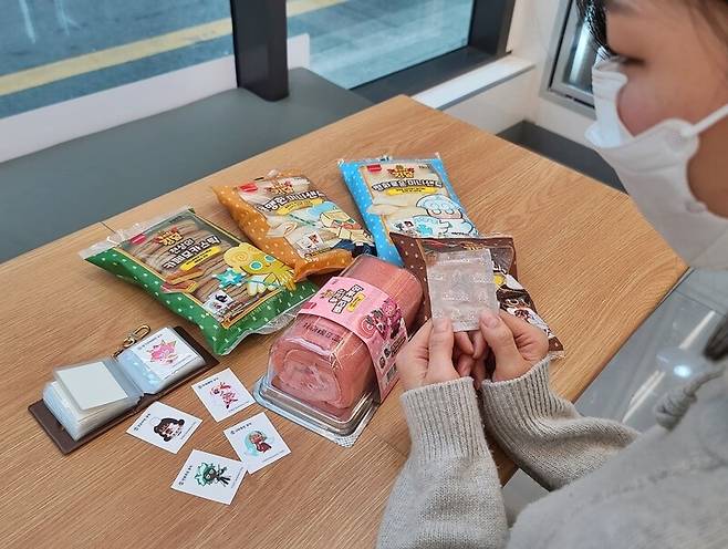 편의점 씨유에서 판매 중인 쿠키런빵 시즌2 상품들과 그 속에 동봉된 띠부띠부씰. 띠부씰 수집 열풍이 불자 사진 속 ‘띠부씰북’ 증정 이벤트도 조기 종료되는 등 큰 관심을 모았다. 씨유 제공