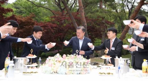문재인 대통령이 25일 청와대 녹지원에서 열린 마지막 기자간담회에서 출입기자들과 막걸리 잔을 들고 건배하고 있다.박지환 기자