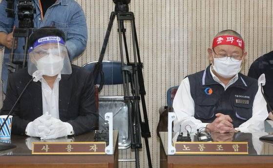 조장우 서울시버스운송사업조합 이사장(왼쪽)과 박점곤 서울시버스노동조합 위원장이 서울시버스노동조합 총파업을 하루 앞둔 25일 서울 영등포구 서울지방노동위원회에서 열린 2차 조정회의에 참석해 있다. [뉴스1]