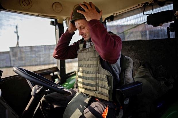 26일(이하 현지시간) 우크라이나 남동부 자포리자에서 농부 유리이가 트랙터에 올라 군용헬멧을 매만지고 있다./로이터 연합뉴스