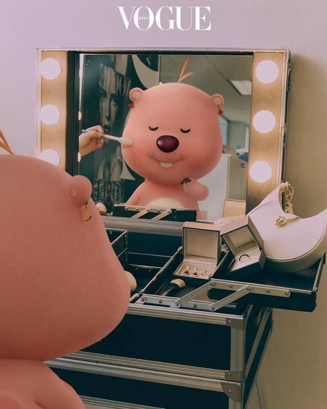 루피의 부캐 잔망 루피가 귀걸이를 착용하고 화장대 앞에 앉아 화장을 받고 있다. 보그 홈페이지