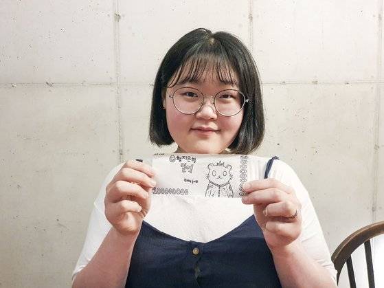 지난 28일 대전 중구의 한 카페에서 기자와 만난 곽지현씨. 20살에 곽씨가 직접 만든 '1억원 종이'를 들고 있다. 양수민 기자