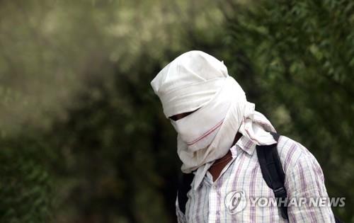 1일 인도 뉴델리서 태양열을 피하고자 얼굴을 수건 등으로 가린 남성. [EPA 연합뉴스 자료사진. 재판매 및 DB 금지]