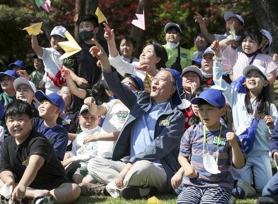 문재인 대통령이 5일 청와대 녹지원에서 열린 2022년 어린이날 100주년 기념 청와대 어린이 초청행사에서 아이들과 종이비행기를 날리며 기념촬영하고 있다. 뉴시스