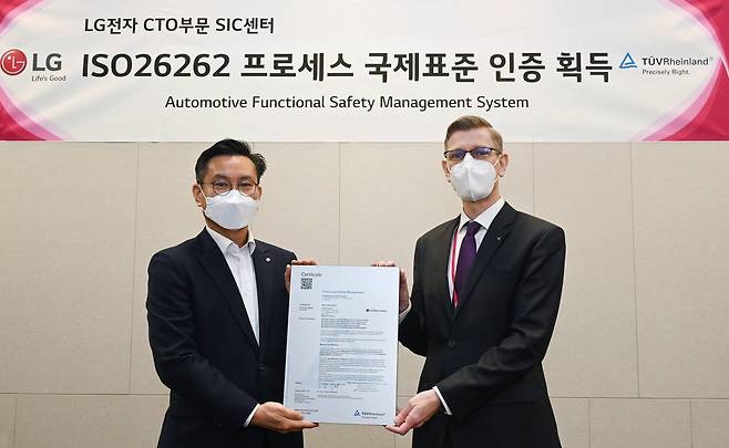 LG전자가 최근 독일 시험ㆍ인증 전문기관 TUV 라인란드(TÜV Rheinland)로부터 차량용 반도체 개발 프로세스에 대한 ‘ISO 26262’ 인증을 받았다. LG전자 SIC센터장 김진경 상무(왼쪽)가 TUV 라인란드 코리아 프랭크 주트너(Frank Juettner) 대표와 함께 기념촬영을 하고 있다. LG전자 제공