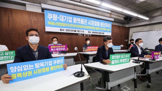 지난해 서울 종로구 참여연대에서 열린 '쿠팡 시장침탈 저지 전국자영업 비상대책위원회' 발족 및 투쟁 선포식에서 한국마트협회 관계자 등 참석자들이 쿠팡을 비롯한 대기업 플랫폼 업체들의 유통 시장 장악 중단 주장을 담은 손팻말을 들고 있다./연합뉴스