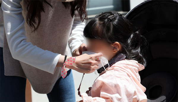 유아들의 마스크 착용 부작용을 밝힌 연구가 계속 나오고 있다. 사진은 지난 1일 서울 인사동 거리에서 한 부모가 자녀에게 마스크를 씌워주는 모습. [사진 출처 = 연합뉴스]