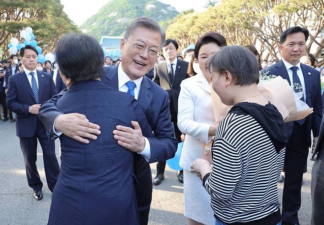 문재인 대통령이 9일 오후 청와대를 걸어 나와 한 시민에게 꽃다발을 건네받은 뒤 포옹하고 있다. 강정현 기자