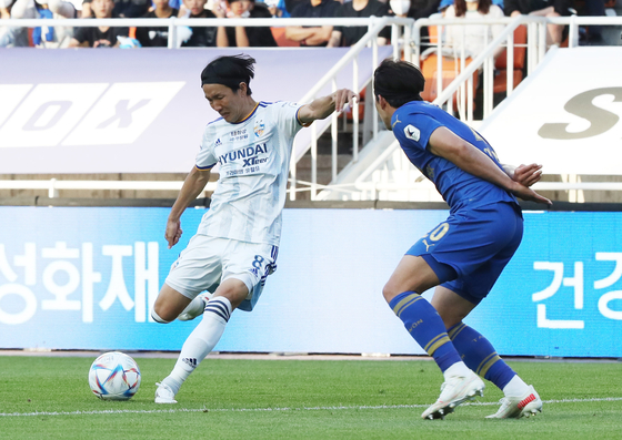 Ulsan Hyundai’s Jun Amano, left plays the ball against Suwon Samsung Bluewings on Thursday at Suwon World Cup Stadium in Suwon. [NEWS1]