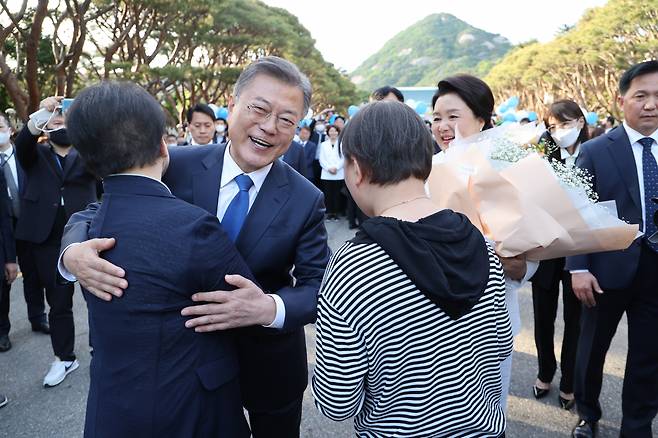 문재인 대통령이 9일 오후 청와대를 나와 분수대 앞으로 향하던 중 꽃다발을 건네준 시민과 포옹하고 있다. [연합]