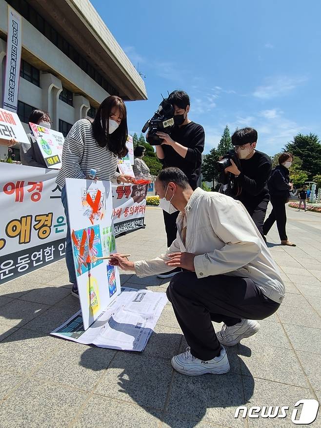 가습기살균제 피해자들과 인천환경운동연합 활동가 등이 10일 오전 인천시청 앞 인천애뜰에서 가진 '가습기 살균제 피해 조정안 거부 기업 규탄 기자회견'에서 대책 마련을 촉구한 데 이어 불매운동 퍼포먼스를 하고 있다.2022.5.10/뉴스1 © News1 박아론 기자