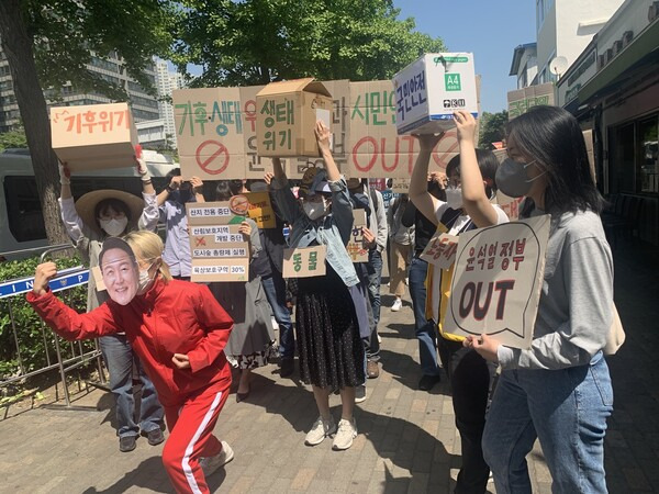 한국환경회의 활동가들이 10일 서울 용산구 삼각지역 앞에서 기자회견을 열고 윤석열 정부의 기후위기 대응 정책을 비판하는 퍼포먼스를 하고 있다. 김윤주 기자