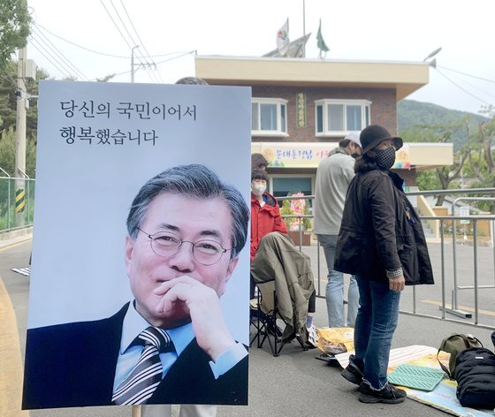 문재인 전 대통령 내외 귀향일인 10일 경남 양산 하북면 평산마을회관 앞에 문 전 대통령 지지자가 문 전 대통령 초상사진으로 만든 피켓을 들어 보이고 있다. 뉴스1