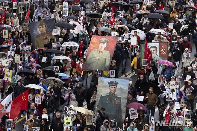 [모스크바=AP/뉴시스] 9일(현지시간) 러시아 모스크바에서 제2차 세계대전 종전 77주년(전승절) 기념 '불멸의 연대' 행진이 열려 2차대전 참전용사 가족들이 고인의 사진을 들고 그들의 희생을 추모하며 행진하고 있다. 2022.05.10.