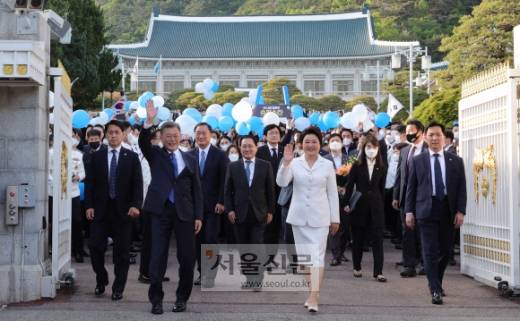 청와대 정문 나서는 文내외  - 문재인 전 대통령과 김정숙 여사가 임기 마지막날인 9일 직원들의 배웅과 함께 청와대 정문을 걸어나오면서 시민들을 향해 인사하고 있다. 박지환 기자