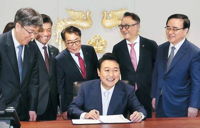 윤석열 대통령이 10일 서울 용산 대통령 집무실에서 참모들과 함께 ‘1호 법안’인 한덕수 국무총리 후보자에 대한 임명동의안에 서명하며 활짝 웃고 있다. 뒷줄 왼쪽부터 김대기 비서실장, 최상목 경제수석, 최영범 홍보수석, 안상훈 사회수석, 김성한 국가안보실장. /연합뉴스