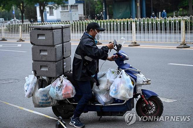 코로나19 확산 속 배달 나선 베이징 슈퍼마켓 직원 (베이징 AFP=연합뉴스) 코로나19 확산세가 이어지는 중국 수도 베이징의 거리에서 10일 한 슈퍼마켓 배달원이 스쿠터를 타고 물품 배달에 나서고 있다. 전날 베이징의 코로나19 신규 감염자 수는 74명으로 파악됐다. 베이징시는 코로나19 확산을 막기 위해 시내 유치원, 초·중·고등학교의 등교 수업을 무기한 연기하는 등 방역을 강화하고 있다. 2022.5.10 leekm@yna.co.kr