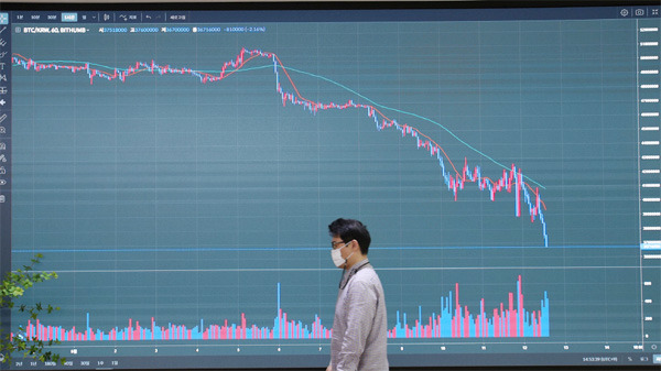 12일 서울 서초구 빗썸 고객센터에 설치된 비트코인의 시세판 앞을 한 고객이 지나가고 있다. 이날 테라·루나 코인 사태 여파로 국내 가상화폐 시장에서 비트코인 가격은 9개월여 만에 처음으로 4000만원 아래로 떨어졌다. [이충우 기자]