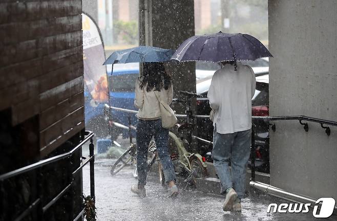 13일 오후 제주시 한림읍 협재해수욕장 인근 도로에서 시민들이 비를 피해 이동하고 있다.  2022.4.13/뉴스1 © News1 오현지 기자
