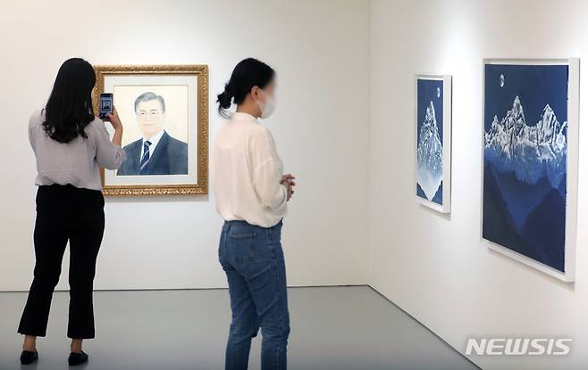 [서울=뉴시스] 조성우 기자 = 13일 오후 서울 중구 로즈앤라임 갤러리에서 문재인 전 대통령에 대한 헌정을 주제로 열린 '문라이즈데이(Moon Rise Day)' 전시회에서 관람객들이 작품을 보고 있다. 2022.05.13. xconfind@newsis.com