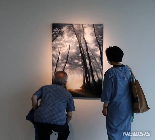 [부산=뉴시스] 박진희 기자 = 가나부산은 10년만에 돌아온 작가 도성욱의 개인전 'Emotion' 작품을 부산 그랜드조선 갤러리에서 선보이고 있다. 숲을 그리는 도 작가는 몇 년 전 불의의 사고 이후 10년 만에 갖는 개인전이다. 그동안 발표한 ‘컨디션’ 시리즈부터 새로 선보이는 ‘이모션’ 시리즈까지 총 30여 점을 오는 6월 12일까지 전시한다. 2022.05.12. pak7130@newsis.com