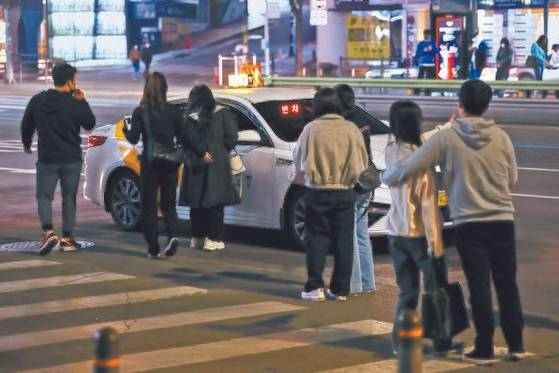 지난달 18일 자정쯤 서울 강남역 근처에서 시민들이 택시를 잡기 위해 모여들고 있다. 거리두기가 해제되어 늦은 술자리가 늘고 있는 가운데 일부 택시 기사들이 사용하는 ‘매크로’ 프로그램 탓에 일반인들이 택시 호출을 하지 못해 피해를 본다는 지적이 나오고 있다. [연합뉴스]
