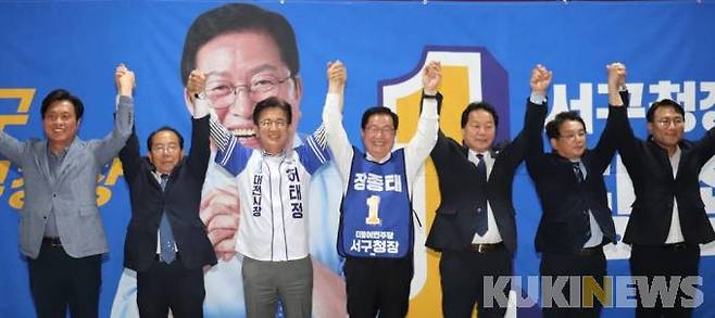 (왼쪽부터) 조승래 국회의원, 송석근 상임위, 허태정 대전시장 후보, 장종태 서구청장후보, 이선용 서구의회 의장, 김창관·유지곤 민주당 서구청장 경선후보가 '원팀'으로 승리하자며 팔을 올렸다. 사진=장종태 캠프.