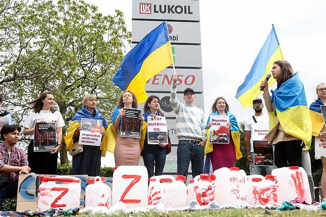 벨기에 브뤼셀 시민들이 13일(현지시간) 러시아 석유·가스 회사 루크오일 본사 앞에서 러시아산 석유에 대한 보이콧을 요구하는 시위를 하고 있다. [AFP]