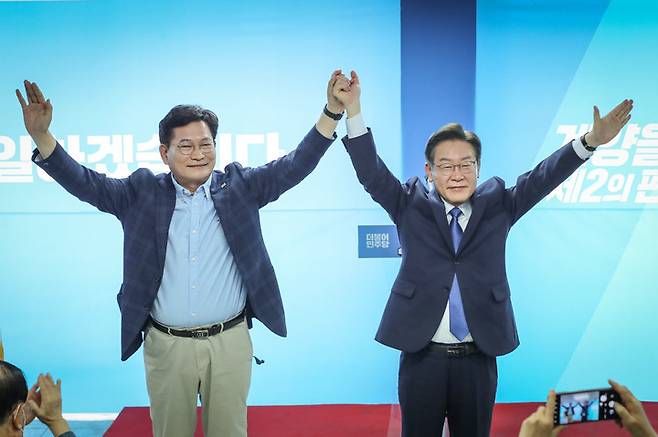 [서울=뉴시스] 전진환 기자 = 송영길 더불어민주당 서울시장 후보가 제8회 전국동시지방선거 함께 치러지는 인천 계양을 보궐선거에 출마한 더불어민주당 이재명 후보 겸 총괄선거대책위원장의 인천시 계양구 선거사무소 개소식에 참석해 이 후보와 손을 잡고 포즈를 취하고 있다.  (사진=송영길캠프 제공)2022.05.14.  photo@newsis.com