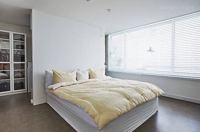 필요 이상으로 넓은 안방은 가벽을 세워 침실, 드레스 룸 겸 파우더 룸으로 구획을 나눴다. 현재는 드레스 룸으로 사용하지만, 언제든 서재로도 활용할 수 있도록 선반을 짜 넣었다. 침대는 시몬스, 전구 모양의 펜던트 조명은 무토 E24.