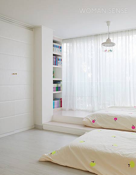두 딸 주하·예하의 침실. 매트리스만 놓아 공간이 여유로워 보이는 효과를 준다. 베란다를 확장한 곳에 계단식 공간을 만들고 책장을 매립해 놀면서 책을 볼 수 있도록 했다. 침구와 빈백은 수제 베딩 브랜드 드플레잉 제품.