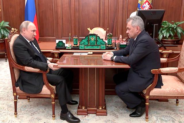 블라디미르 푸틴(왼쪽) 러시아 대통령이 지난달 21일 모스크바 크렘린궁에서 세르게이 쇼이구 국방장관과 면담하며 어색한 자세로 탁자를 움켜쥐고 있다. 모스크바=AP 연합뉴스
