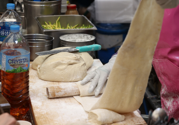 지난달 28일 서울 종로구 광장시장에서 밀가루로 만두피를 만드는 상인의 모습. [사진 출처 = 연합뉴스]