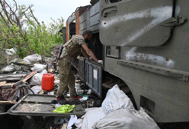 우크라니아 군인이 13일(현지시간) 하르키우 동부 지역에 파괴된 채 놓인 러시아군 장비를 들여다 보고 있다. /AFPBBNews=뉴스1