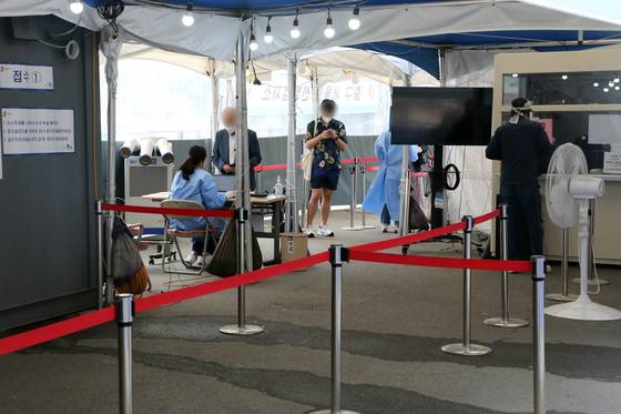(서울=뉴스1) 황기선 기자 = 13일 오전 서울 중구 서울역광장에 마련된 신종 코로나바이러스 감염증(코로나19) 임시선별진료소에서 시민들이 검사를 기다리고 있다. 질병관리청 중앙방역대책본부(방대본)는 이날 0시 코로나19 신규 확진자가 3만2451명 발생했다고 밝혔다. 2022.5.13/뉴스1