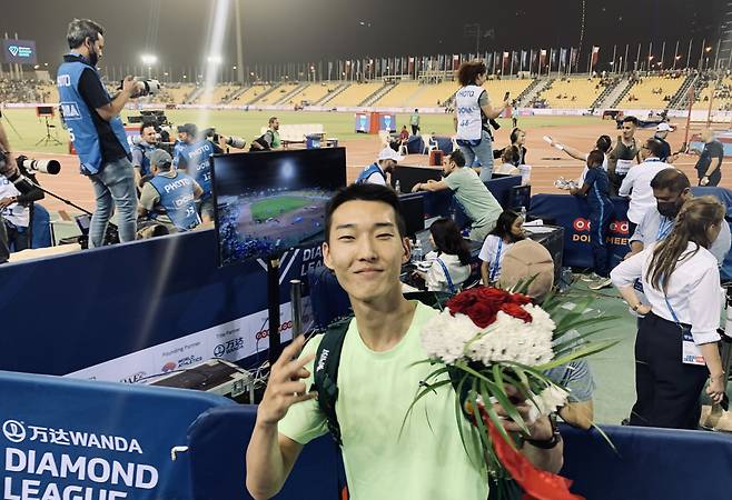 우상혁이 14일(한국시간) 카타르 도하에서 열린 세계육상연맹 다이아몬드리그 개막전에서 우승한 뒤 받은 꽃을 들고 포즈를 취하고 있다. [연합]