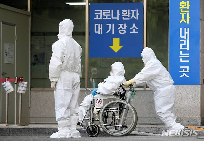 [서울=뉴시스] 서울 은평구 서울시립서북병원에서 의료진들이 환자를 이송하고 있다. photo@newsis.com