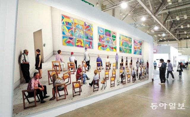 부산 해운대구 벡스코에서 열린 ‘아트부산 2022’ 전시장에서 15일 관람객이 데이비드 호크니의 대작 ‘Pictures at an
 Exhibition’(2018년)을 감상하고 있다. 이 작품은 미국 유명 갤러리인 ‘그레이 갤러리’ 부스 밖에 걸려 있어 오가는
 관람객들의 눈길을 사로잡았다. 부산=박경모 기자 momo@donga.com