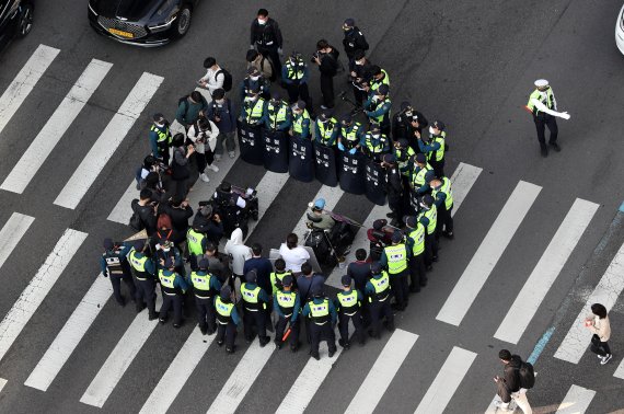 17일 오전 서울 용산구 신용산역 인근에서 출근길 행진을 하는 전국장애인자별철폐연대(전장연) 회원들이 경찰에 둘러싸여 있다. /사진=뉴시스