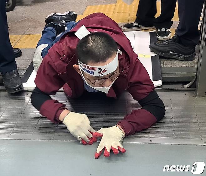 전국장애인철폐연대 활동가가 18일 오전 9시 서울 삼각지역 4호선 열차에서 장애인 권리예산 마련을 요구하는 오체투지 집회를 하고 있다. 약 2분간 열차가 지연됐다. © News1 조현기 기자
