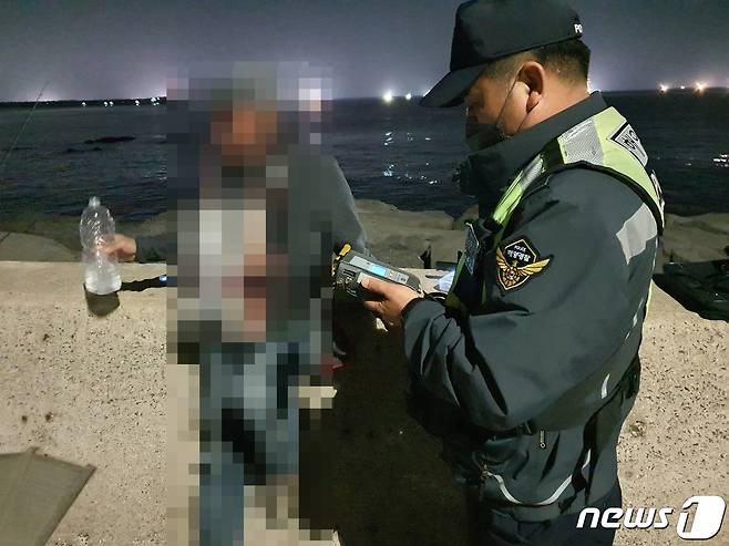 제주 해경이 지난 17일 오후 술을 마시고 레저보트를 운항한 A씨에 대한 음주측정을 하고 있다.(제주해양경찰서 제공) 2022.5.18/뉴스1© News1