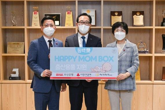 부산사회복지공동모금회 박은덕 사무처장과 부산은행 박명철 경영전략그룹장, 부산돌봄사회서비스센터 안혜경 센터장(왼쪽부터)이 해피맘박스 전달식에서 기념사진을 찍고 있다./제공=BNK금융그룹