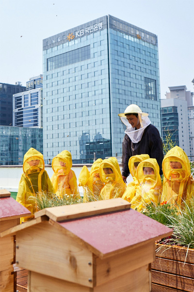 KB금융그룹 직원 가족들이 KB국민은행 본관 옥상에 설치된 `K-Bee` 도시 양봉장에서 벌 키우기 체험 활동을 하고 있다. [사진 제공 = KB금융그룹]