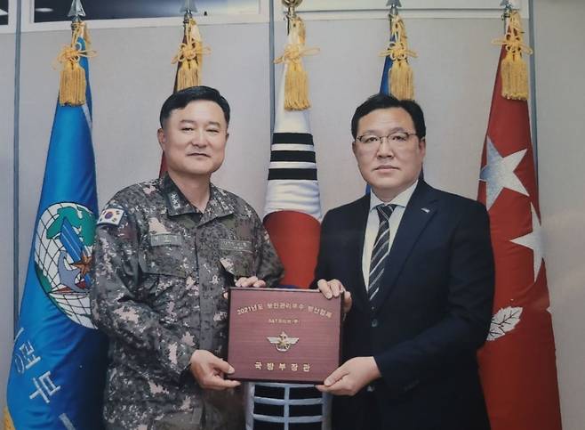 SNT모티브 특수사업본부 김택성 이사(오른쪽)가 지난 17일 국방정보본부 최성목 정보기획부장으로부터 국방부장관 표창을 받고 기념촬영을 하고 있다./사진제공=SNT모티브