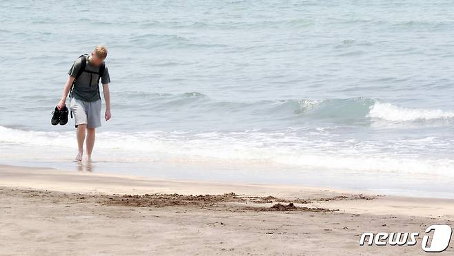 낮 최고기온이 26도에 육박한 18일 오후 제주시 삼양동 검은모래해변에서 한 외국인이 더위를 식히고 있다. 2022.5.18/뉴스1 © News1 오현지 기자