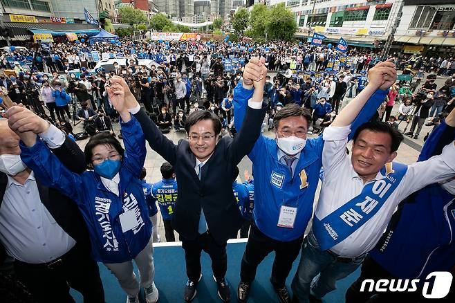 김동연 더불어민주당 경기도지사 후보(가운데)와 윤호중 공동선거대책위원장(오른쪽 두 번째)을 비롯한 참석자들이 19일 경기 수원시 팔달구 지동교에서 열린 김 후보 유세단 출정식에서 손을 맞잡고 있다. 왼쪽 두 번째 부터 김 후보 부인 정우영 여사, 김 후보, 윤 위원장, 이재준 수원시장 후보. 2022.5.19/뉴스1 © News1 국회사진취재단