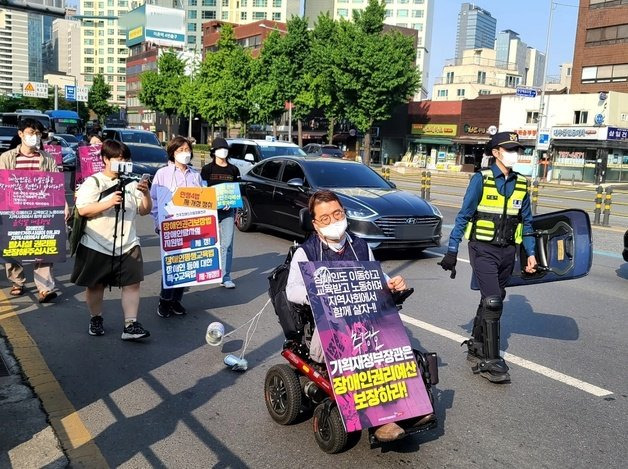 전국장애인차별철폐연대 회원들이 19일 오전 서울 용산구 신용산산역에서 삼각지역까지 ‘장애인 권리예산 22년 추경 반영을 위한 긴급행동’ 행진 시위를 진행하고 있다. 뉴스1