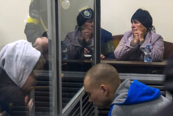 18일 키이우의 법정에서 민간인 사살 혐의로 기소된 러시아군의 바딘 시시마린 병장 근처에 유족이 앉아있다. 키이우/로이터 연합뉴스